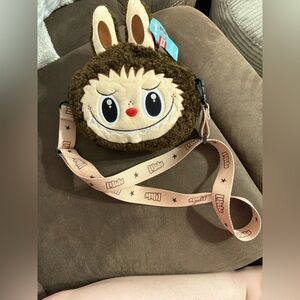 Pop Mart POP LAND Labubu plush messenger bag in brown.
